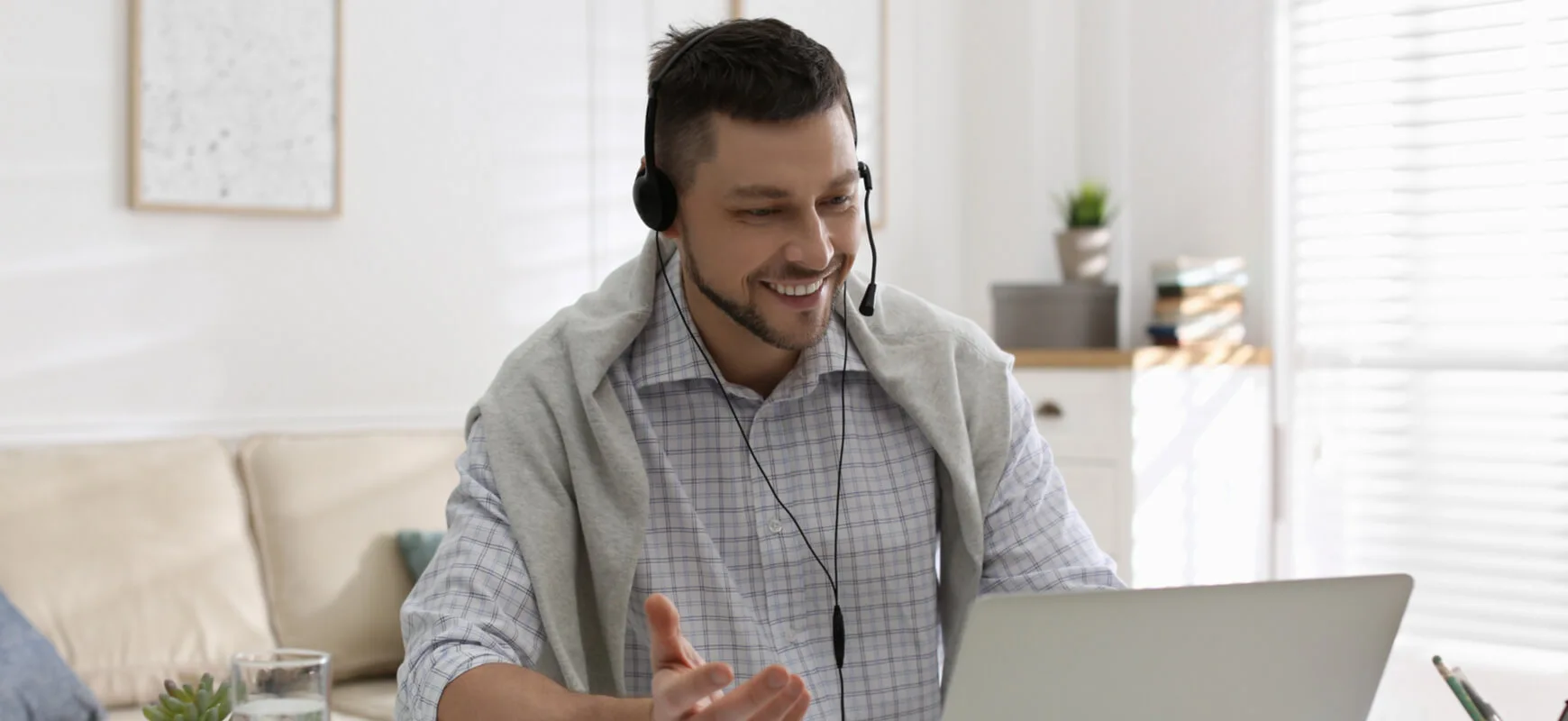 man on headset in front of laptop